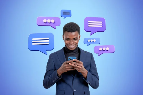Africano Sorridente Empresário Digitando Telefone Bolhas Mensagem Texto Fundo Azul — Fotografia de Stock