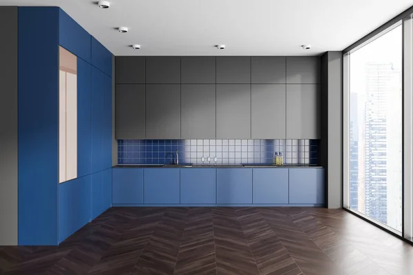 Grey and blue kitchen interior with cooking space and sink with stove, hidden cabinet with minimalist kitchenware and panoramic window on skyscrapers. 3D rendering