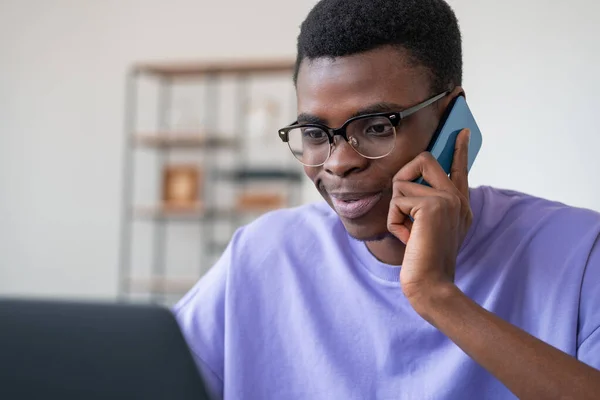 Улыбающийся Африканский Бизнесмен Звонит Телефону Смотрит Экран Ноутбука Офисная Комната — стоковое фото