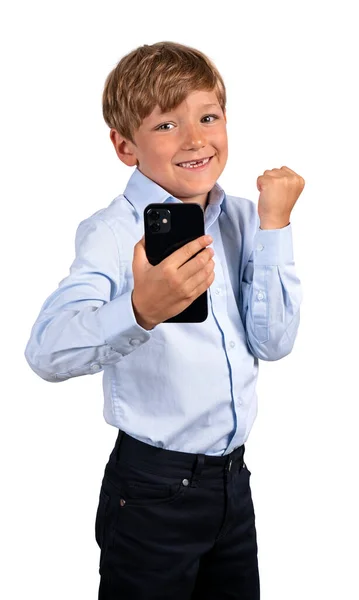 笑着看着相机的孩子举着拳头和手机 与白色背景隔离 游戏和成就的概念 — 图库照片