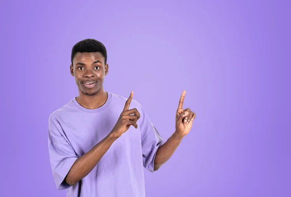 カジュアルウェアを身に着けているアフリカ系アメリカ人実業家は 背景に空の紫色の壁の近くの指で指摘している モデルの概念 成功したビジネス人 ショー — ストック写真