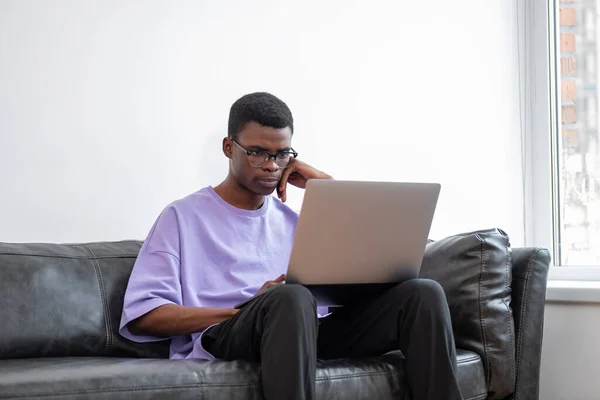 Hombre Africano Joven Usando Ordenador Portátil Vista Lateral Trabajo Sofá — Foto de Stock