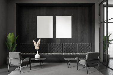 İçinde kanepe, iki koltuk ve sehpa olan karanlık bir iş odası. Şehir manzaralı panoramik bir pencere. Ofis salonundaki dinlenme alanı. İki maket poster. 3B görüntüleme