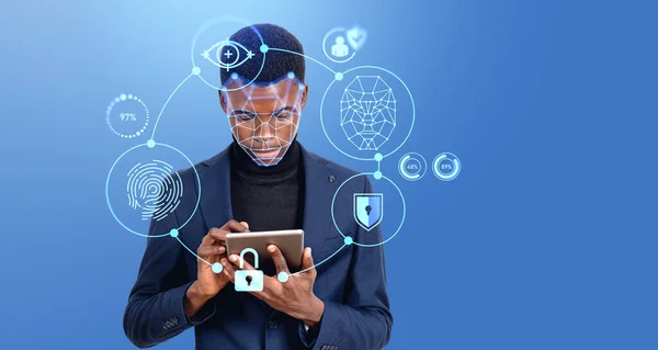 青の背景に没入型生体認証スキャンインターフェイスを持つタブレットコンピュータを使用して深刻な若いアフリカ系アメリカ人ビジネスマンの肖像画 モックアップ — ストック写真
