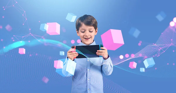 快乐的小男孩在蓝色背景下使用手持控制台 游戏和网络空间的概念 — 图库照片
