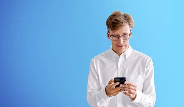 Glücklicher Geschäftsmann Tippt Telefon Den Händen Leerer Blauer Kopierraum Hintergrund — Stockfoto