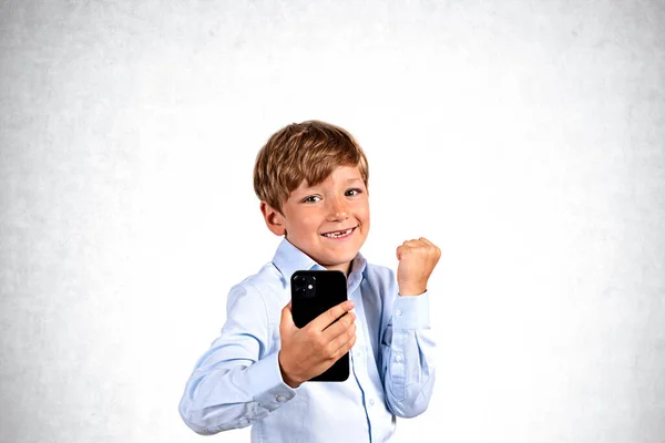 Portrait Cheerful Celebrating Boy Smartphone Standing Concrete Wall Background Concept — Stock Photo, Image