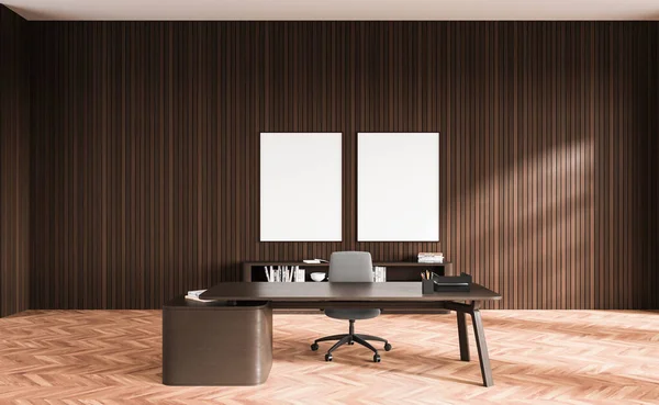 Interior of minimalistic CEO office with dark wooden walls, wooden floor, dark wooden computer table and two vertical mock up posters. 3d rendering