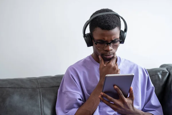 Fiatal Komoly Afrikai Férfi Aki Táblagépet Néz Álltól Állig Fülhallgatót — Stock Fotó