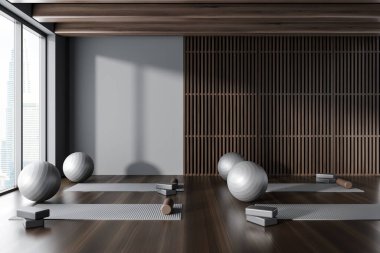 Gri ve koyu ahşap duvarları, koyu ahşap zemini, yoga minderleri ve gri fittopları olan modern yoga stüdyosunun içi. 3d oluşturma