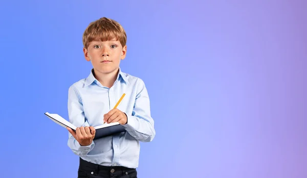 Портрет Серьезного Мальчика Синей Рубашке Пишущего Блокноте Синем Фоне Концепция — стоковое фото