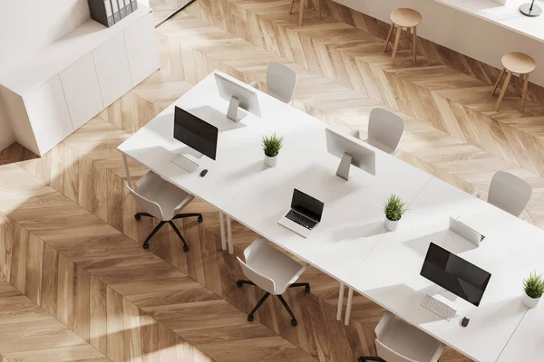 Top view of white office interior with chairs and pc computer with laptop on desk, hardwood floor. Coworking corner with sideboard and folders. 3D rendering