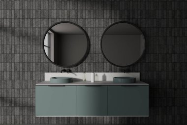 Gri fayanslı duvarları olan şık bir banyo, koyu yeşil dolapta duran çift lavabo ve iki yuvarlak ayna. 3d oluşturma