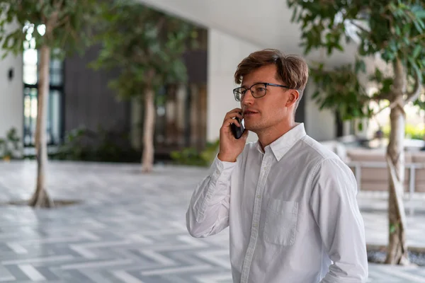 Portret Poważnego Młodego Europejskiego Biznesmena Białej Koszuli Okularach Mówiącego Smartfonie — Zdjęcie stockowe