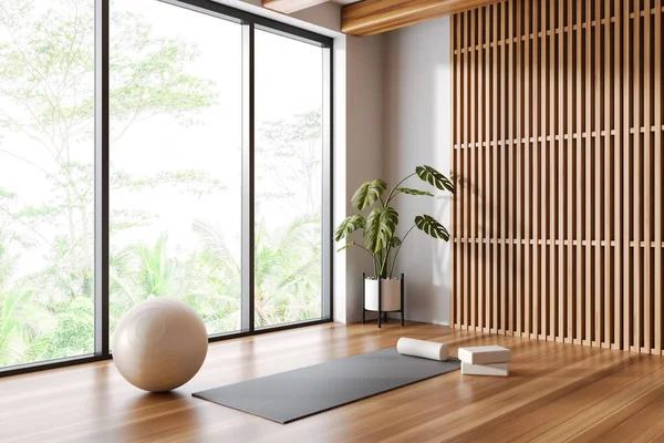 Corner of panoramic yoga studio with white and wooden walls, wooden floor, yoga mat and white fitball. 3d rendering