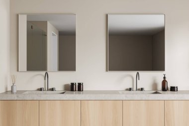 Çift lavabolu, iki kare aynalı, ahşap raflı bej bir banyo. Banyo aksesuarları, kamış ayırıcı ve el sabunu şişesi. 3B görüntüleme