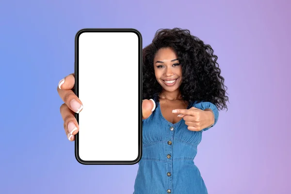 黒の女性は 指の大規模なスマートフォンのモックアップを空のディスプレイ グラデーションの背景を指して笑顔 ソーシャルメディアとネットワークの概念 — ストック写真