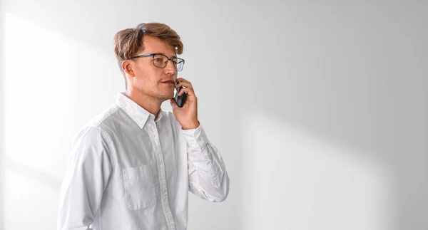 眼鏡のビジネスマンは 携帯電話 空のコピースペースの影の壁に白いシャツの肖像画を呼び出します ビジネスネットワーク オンライン通信 会議の概念 — ストック写真