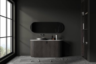 Koyu gri duvarları, beton zemini, koyu ahşap dolapta duran rahat lavabosu ve oval aynası olan şık bir banyo. 3d oluşturma