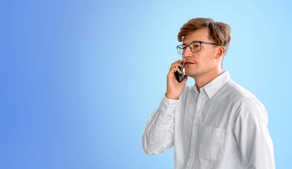 Ciddi Genç Avrupalı Adamının Portresi Mavi Arka Planda Akıllı Telefondan — Stok fotoğraf