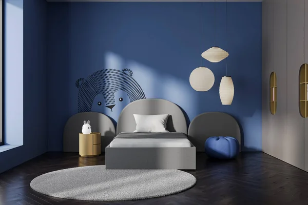Modern blue baby bedroom interior with bed and shelf, nightstand and carpet on hardwood floor. Sleeping room with soft pouf and bear drawing on wall. 3D rendering