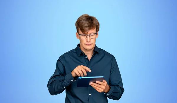 Mavi Arka Plan Üzerinde Tablet Bilgisayar Kullanan Avrupalı Genç Bir — Stok fotoğraf