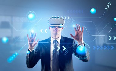 VR gözlükleriyle çalışan iş adamı, elleri soyut parlayan holograma dokunuyor, dünya küreleri ve oklarla bağlantı hatları. Sanal dünya kavramı