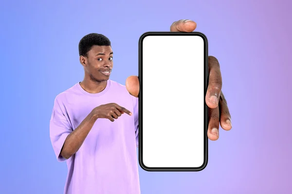 Siyahi Genç Adam Gülümsüyor Parmağıyla Büyük Akıllı Telefonu Işaret Ediyor — Stok fotoğraf