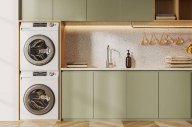 Beyaz duvarları, ahşap zemini, yeşil dolapları, modern çamaşır makinesi, kurutma makinesi ve rahat lavabosu olan modern çamaşır odasının içi. 3d oluşturma