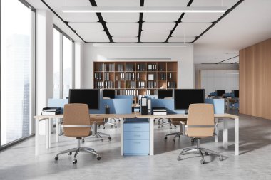 Beyaz duvarları, beton zemini, ahşap ve mavi bilgisayar masaları ve klasörlü kitaplıkları olan modern açık uzay ofisinin içi. 3d oluşturma