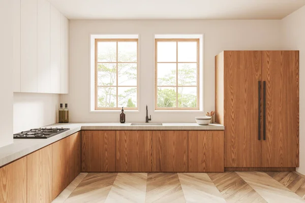 Interior of stylish kitchen with white walls, wooden floor, white cupboards and wooden cabinets with built in cooker and sink with two windows above it. 3d rendering