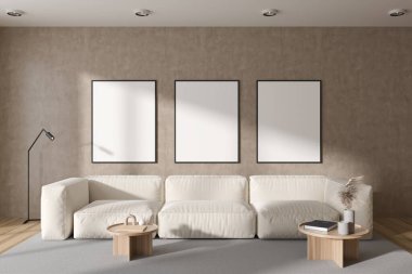 Bej oturma odasının içinde kanepe, modern dekorasyonlu kahve masası, ahşap döşemeli halı. Sıraya dizilmiş üç tane tuval posteri. 3B görüntüleme