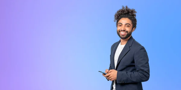 紫色の壁の近くに立ってスマートフォンを保持エレガントなスーツで陽気な若いアフリカ系アメリカ人ビジネスマンの肖像画 ビジネスコミュニケーションの概念 スペースのコピー — ストック写真