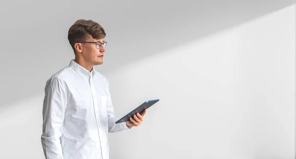 Beyaz Gömlekli Elinde Tablet Bilgisayarla Beyaz Duvarın Yanında Duran Konsantre — Stok fotoğraf
