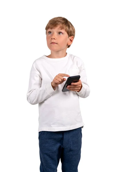 男孩沉思的样子手里拿着电话 被白色的背景隔离了 流动应用和学校教育的概念 — 图库照片
