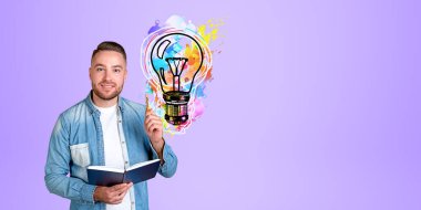 Elinde not defteri ve kalemle gülümseyen genç sakallı üniversite öğrencisi elinde renkli ampul çizimiyle mor duvarın yanında duruyordu. İyi fikir kavramı. Boşluğu kopyala