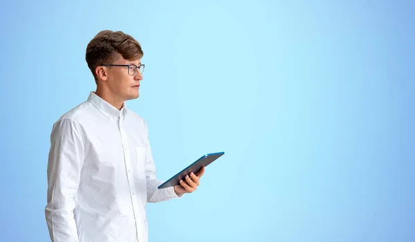 Beyaz Tişörtlü Elinde Tablet Bilgisayarla Mavi Duvarın Yanında Duran Avrupalı — Stok fotoğraf