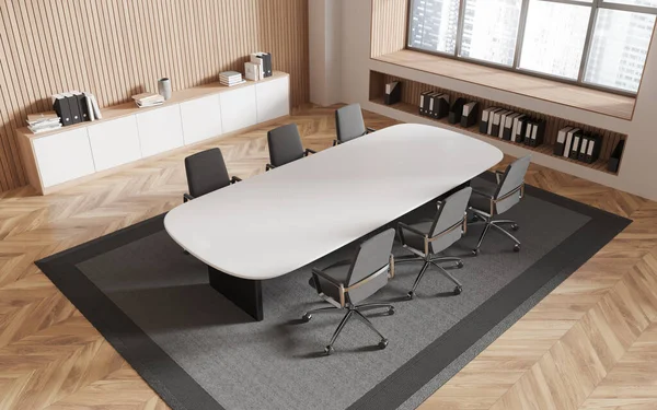 Top view of modern office meeting room with beige and wooden walls, wooden floor, long conference table with rows of chairs and big window with cityscape. 3d rendering