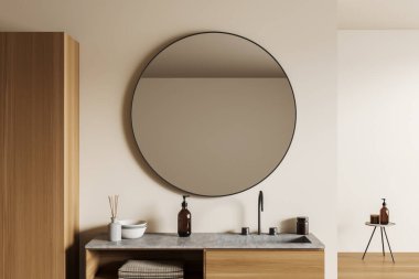 Lavabosu ve büyük yuvarlak aynası olan bej bir banyo. Banyo aksesuarları ve dekorasyonu olan minimalist kostümcü, sabun şişeli tabure. 3B görüntüleme