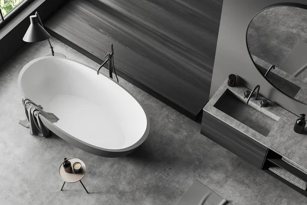 浴室内部的顶部视图 浴缸在灰色混凝土地板上 浴室角落与水池和镜子 配件在梳妆台上 热带地区的全景窗口 3D渲染 — 图库照片