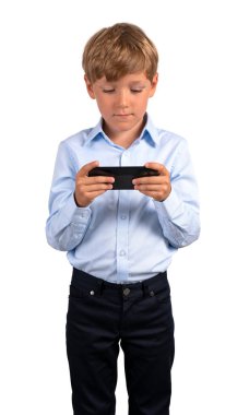Ciddi küçük bir çocuğun resmi giysiler içinde elinde akıllı telefon olan ve beyaz arka planda izole edilmiş ekranına bakan portresi. E-öğrenme ve sosyal medya kavramı. Oyun ve teknoloji