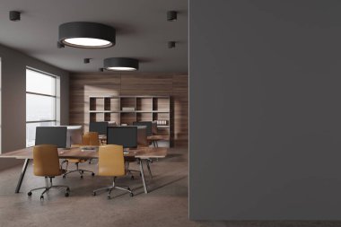 Gri ve ahşap duvarları, beton zemini, sarı sandalyeli büyük bilgisayar tabloları ve sağında boş fotokopi duvarı olan modern açık uzay ofisinin içi. 3d oluşturma