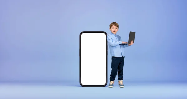 Σοβαρό Μικρό Αγόρι Παιδί Φορητό Υπολογιστή Στέκεται Κοντά Μεγάλο Smartphone — Φωτογραφία Αρχείου