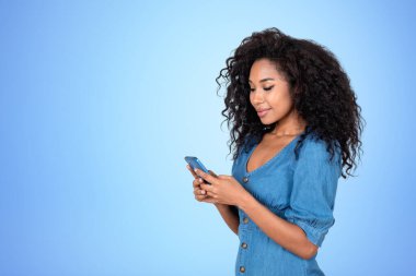 Telefonla yazı yazan gülümseyen Afrikalı kadın, boş bir fotokopi masalı arka planında portre. Ağ ve iletişim kavramı