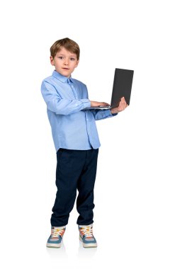 Beyaz arka planda izole edilmiş dizüstü bilgisayarlı konsantre çocuk portresi. E-öğrenme ve sosyal medya kavramı. Modern teknoloji ve internet bağlantısı