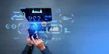 İşadamı akıllı telefona dokunuyor, dizüstü bilgisayarla çalışıyor. İş paneli, grafikler, ölçüler ve KPI ile sanal ekran, üst görünüm. Performans yönetimi ve analiz kavramı