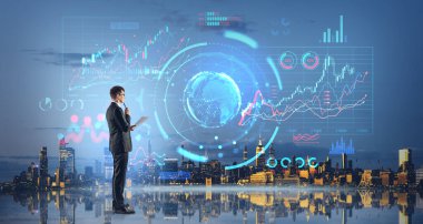 Dijital finansal diyagramlara ve şehir siluetindeki gezegen hologramlarına bakan düşünceli bir iş adamı. İnternet bağlantısı, borsa ticareti ve yatırım kavramı. New York