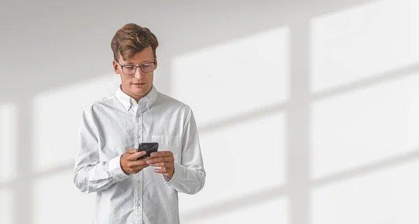 Gözlüklü Bir Adamı Elinde Telefonla Yazı Yazıyor Boş Beyaz Arka — Stok fotoğraf