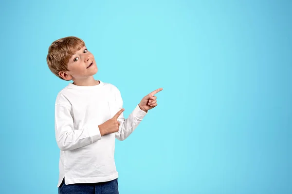 Хлопчик Дивиться Камеру Пальці Вказують Сторону Копіює Блакитний Фон Концепція — стокове фото