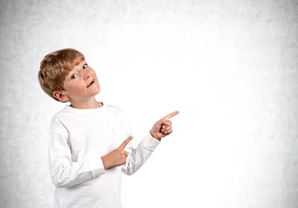 Хлопчик Дивиться Камеру Пальці Вказують Сторону Копіює Порожній Сірий Фон — стокове фото